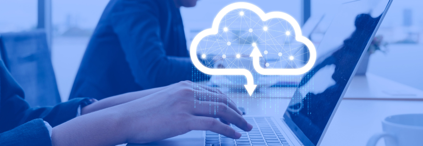 Businessman working at cloud data icon, a man sitting on a wooden table and using a contemporary laptop by the window. Concept of close-up of a hand printed on a laptop.